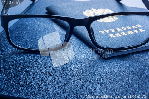 Image of Glasses on diploma of higher education and employment history book