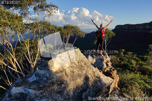 Image of Woman top of mountain exuberant success