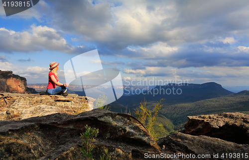 Image of Woman peaceful yoga on mountain summit