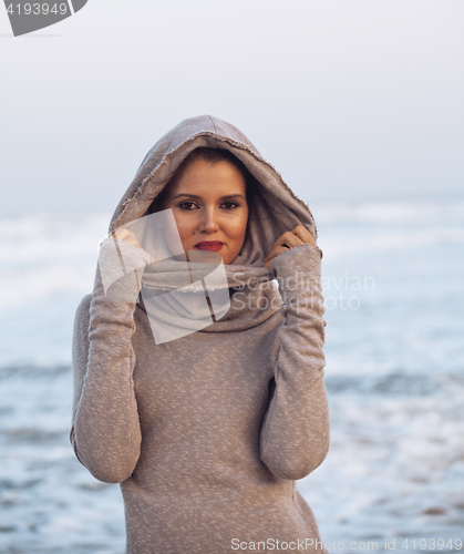 Image of young pretty woman in sweater at seacoast walking relaxing