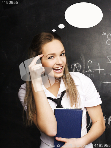 Image of portrait of happy cute student with book in classroom