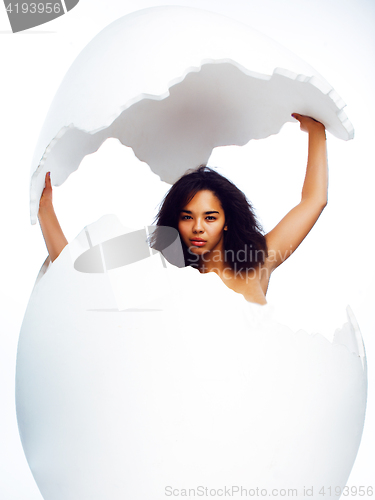 Image of young pretty african american woman in big cracked egg isolated on white background, fashion people concept 