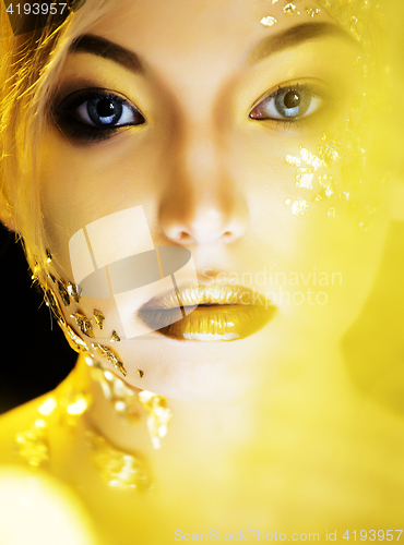 Image of beauty blond woman with gold creative make up, bokeh on yellow background 