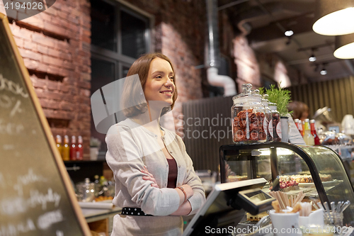 Image of happy woman or barmaid at cafe counter