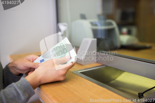 Image of hands with money at bank or currency exchanger