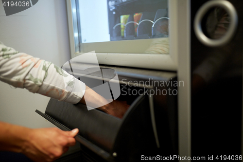 Image of hand taking purchase from vending machine