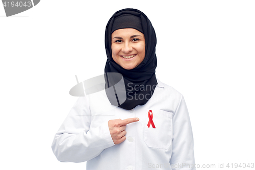 Image of muslim doctor in hijab with red awareness ribbon
