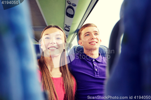 Image of happy teenage couple or passengers in travel bus