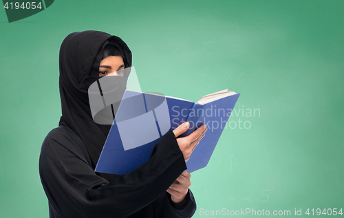 Image of muslim woman in hijab reading book over white