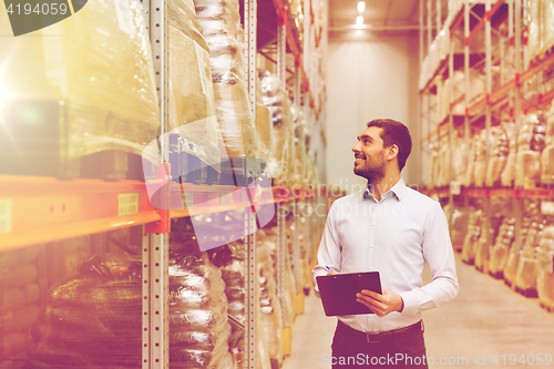 Image of businessman with clipboard at warehouse