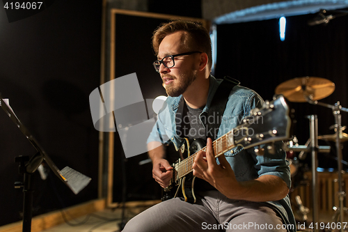 Image of man playing guitar at studio rehearsal