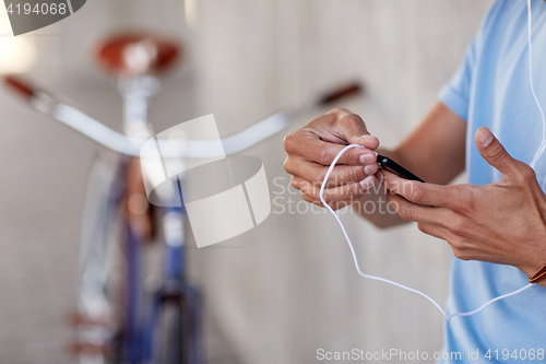 Image of man with earphones and smartphone listening music