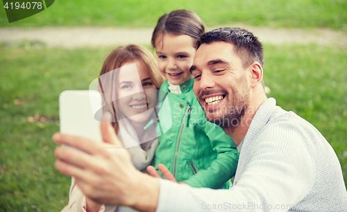 Image of happy family taking selfie by smartphone outdoors