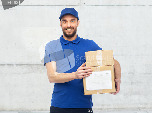 Image of happy delivery man with parcel boxes