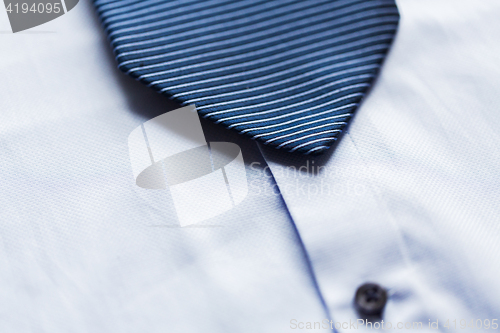 Image of close up of shirt and blue patterned tie