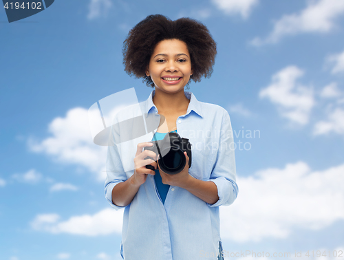 Image of happy african american woman with digital camera