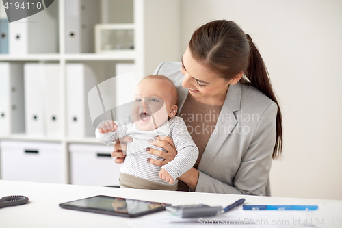Image of happy businesswoman with baby working at office