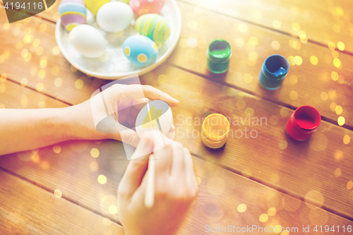 Image of close up of woman hands coloring easter eggs