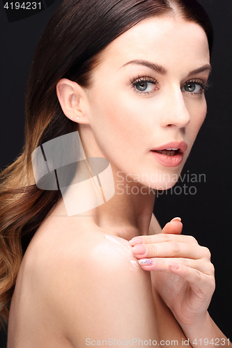 Image of Beautiful young woman rubbed cream 