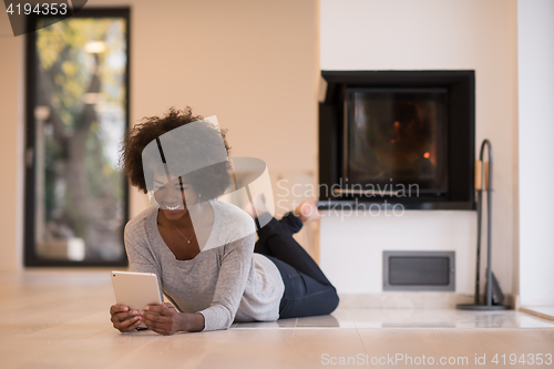 Image of black women used tablet computer on the floor