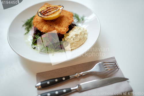 Image of close up of fish salad with roasted lemon on plate