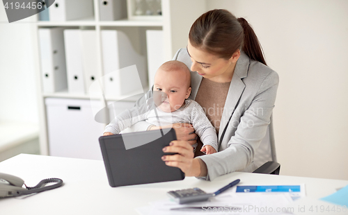 Image of businesswoman with baby and tablet pc at office