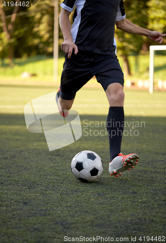 Image of soccer player playing with ball on football field