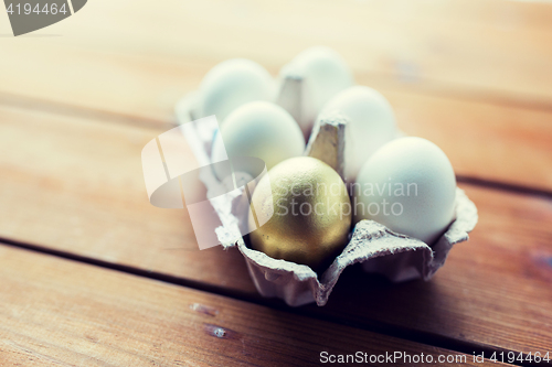 Image of close up of white and gold eggs in egg box