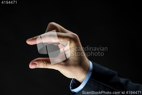 Image of close up of businessman hand showing small size