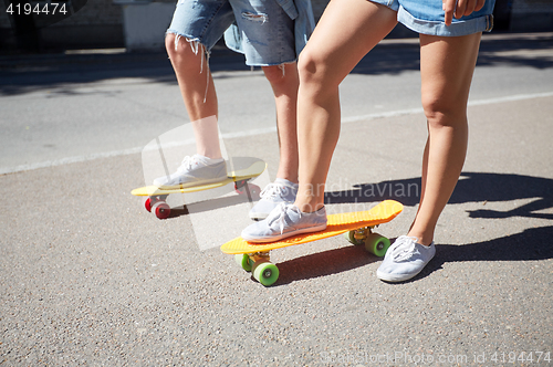 Image of teenage couple riding skateboards on city street