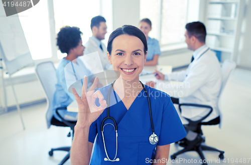 Image of happy doctor over group of medics at hospital