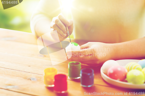 Image of close up of woman hands coloring easter eggs