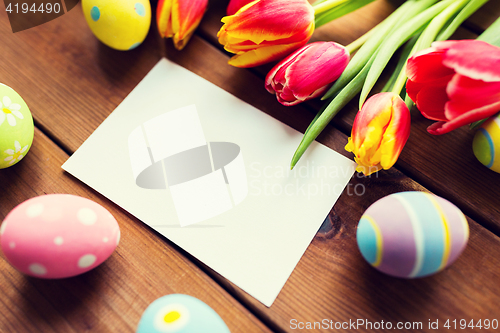Image of close up of easter eggs, flowers and white paper