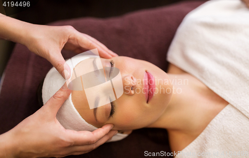 Image of woman having face and head massage at spa