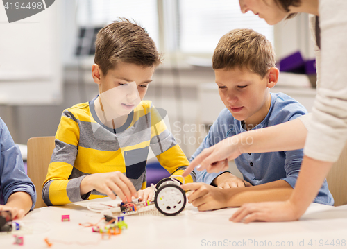 Image of happy children building robot at robotics school