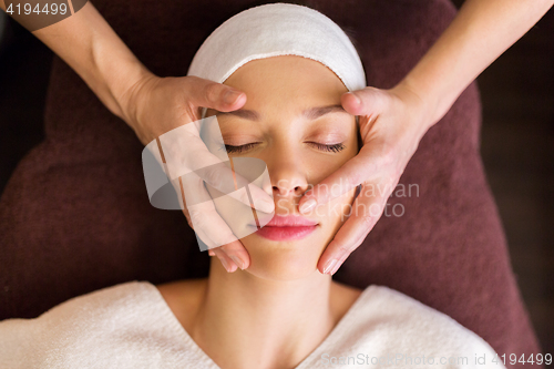 Image of woman having face and head massage at spa