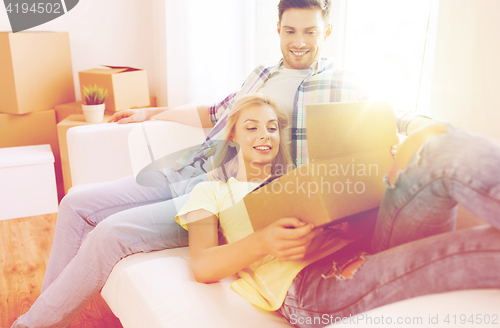 Image of happy couple with big cardboard boxes at new home