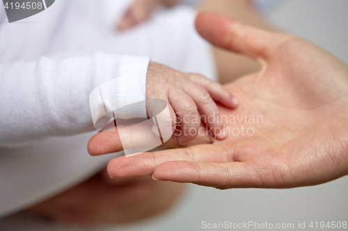 Image of close up of mother and newborn baby hands