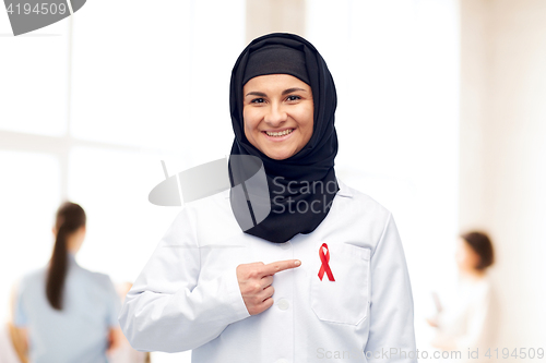 Image of muslim doctor in hijab with red awareness ribbon