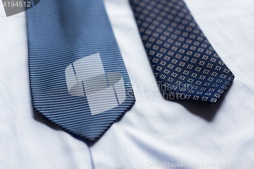 Image of close up of shirt and blue patterned ties