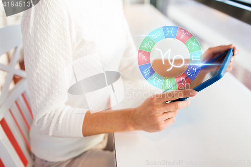 Image of woman with tablet pc and zodiac signs at cafe