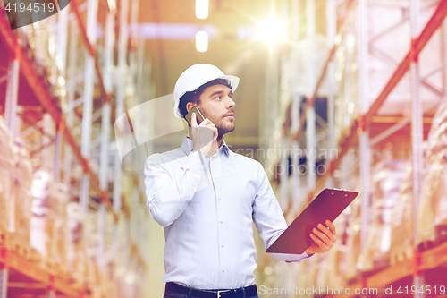 Image of man with clipboard and smartphone at warehouse