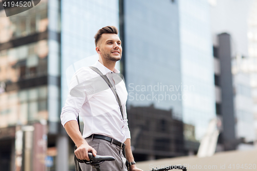 Image of young man with bicycle on city street