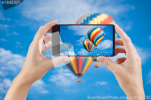 Image of Female Hands Holding Smart Phone Displaying Photo of Blue Sky wi