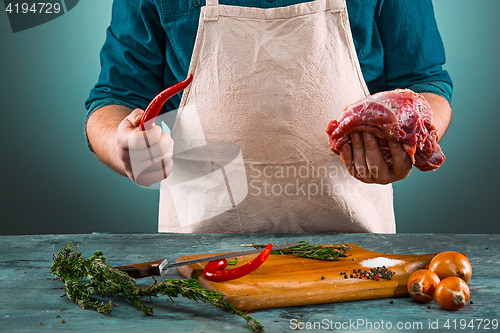 Image of Butcher with pork meat on kitchen