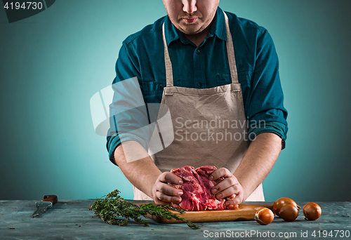 Image of Butcher cutting pork meat on kitchen