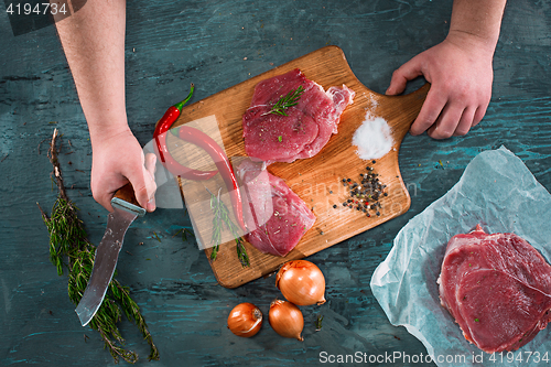 Image of Butcher cutting pork meat on kitchen