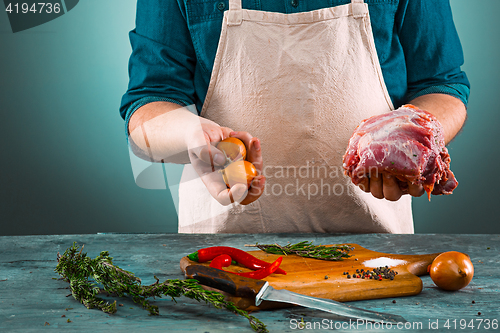 Image of Butcher with pork meat on kitchen