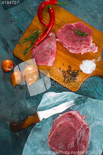 Image of Pieces of raw pork steak with spices and herbs rosemary