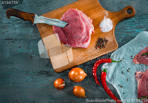 Image of Pieces of raw pork steak with spices and herbs rosemary